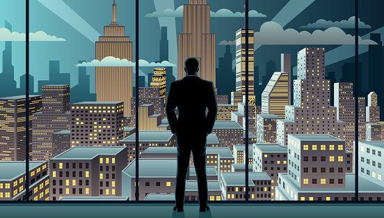 Businessman watching over the city from the window of his office.