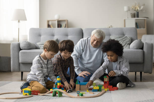 istock Elderly grandpa watching three multiethnic little grandsons playing game 1480370457