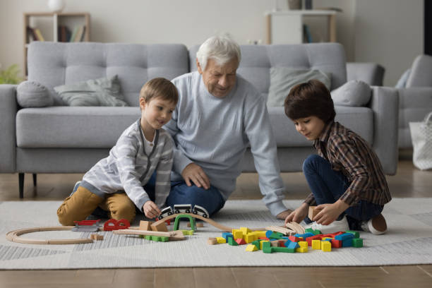 istock Two cheerful kids and grandpa playing constructor game 1480370473