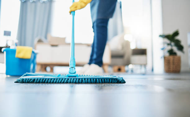 Housekeeping, Reinigung und Hausmädchen mit einem Wischmopp, um den Wohnzimmerboden in einem Haus zu reinigen. Hausangestellte, Putzfrau und Hausfrau, die in ihrem Haus den Boden für Bakterien, Staub oder Schmutz wäscht. – Foto
