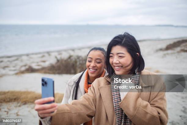 Two Young Women Taking A Selfie On A Beach Stock Photo - Download Image Now - 20-29 Years, 30-39 Years, Adult