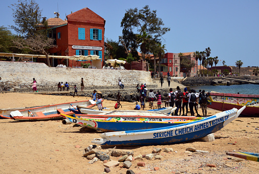 Island of Gorée, Dakar, Senegal: colorful boats on the 'Petite Plage' beach and  'Hostellerie du Chevalier de Boufflers', small hotel on Hesse Street, overlooking the downtown beach (the 'Petite Plage'). Hotel in a historic building named after Stanislas-Jean, Knight of Boufflers (later Marquis), a wise administrator as governor of Senegal (18th century), he would have there 57 bastard children. Hesse Street and Estrées fort in the background.