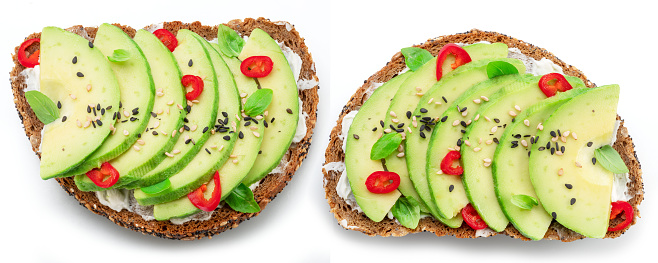 Avocado toasts - bread with avocado slices, pieces of chilli pepper and black sesame isolated on white background. Top  view.
