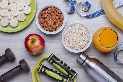 Healthy food. Fruits, almonds, oatmeal, orange juice on a white table. Fitness. Flat top view