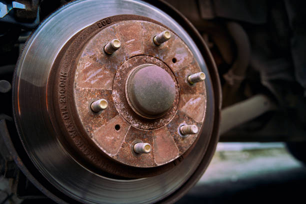 A collection of old, rusty car brake discs, stacked together, showing signs of significant wear and weathering. Perfect for themes related to automotive repair, vehicle maintenance, and recycling of car parts