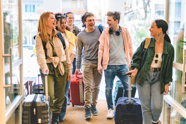group of university college tourist walking inside the hotel with suitcases -young happy students enjoying summer holiday-tourism vacation and lifestyle concept with people-youth culture-spring time - group of people women beach community imagens e fotografias de stock