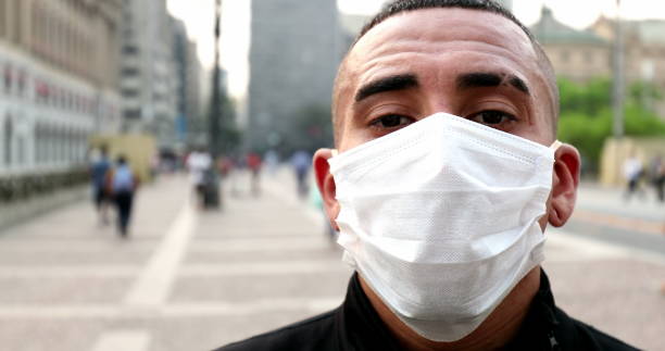 istock Hispanic latin mixed race man putting covid-19 face mask 1480385408