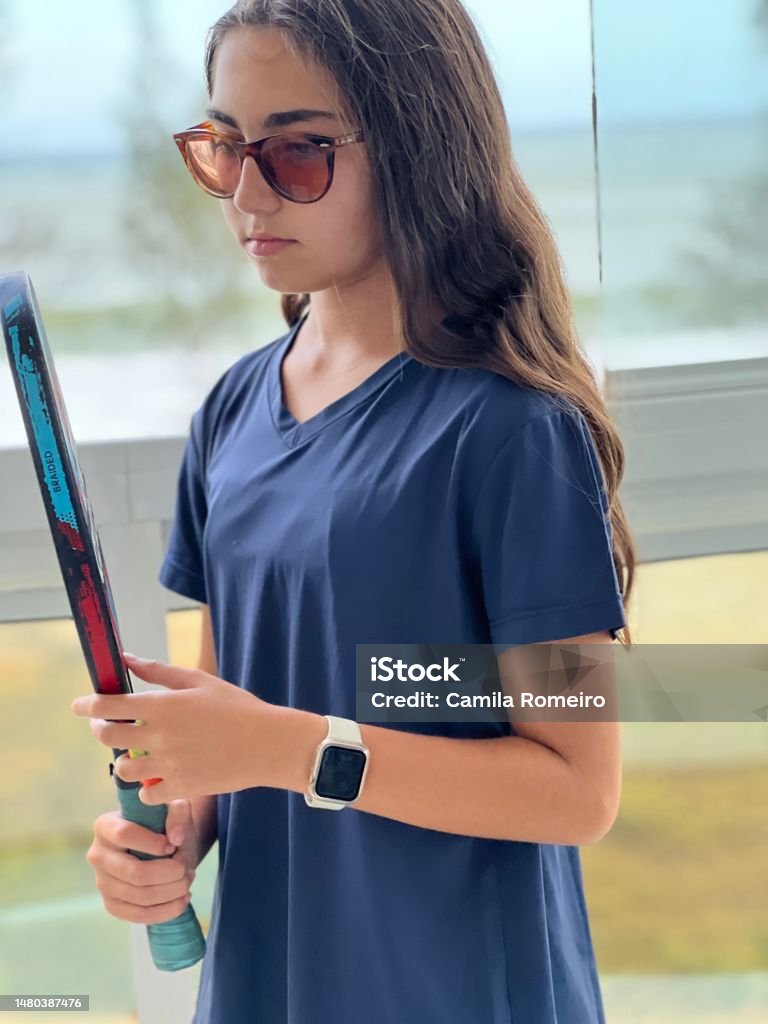 Tennis player Girl holding a beach tennis racket and ball 12-13 Years Stock Photo