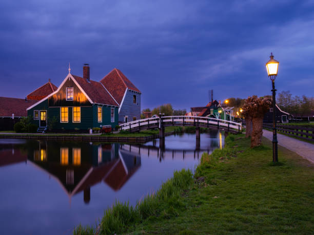 illuminated dutch scene at dusk: zaanse schans. - zaanse schans bridge house water imagens e fotografias de stock