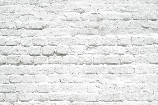 Old grunge white painted brick wall texture background. Loft-style wall