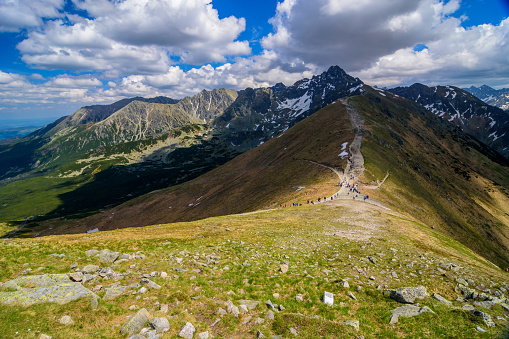 View of the High Tatras from the peaks of Kasprowy Wierch. Tourists on the trail.
