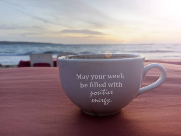 istock Positive text om a cup of coffee or tea on red table with beach sunset view. 1480408776
