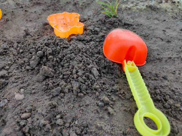 Colorful plastic children's toys in the sand. Concept of sand for children. Top view. Space for text. Flat lay, top view, copy space