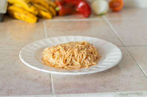 portion of spaghetti with stew served on a white plate