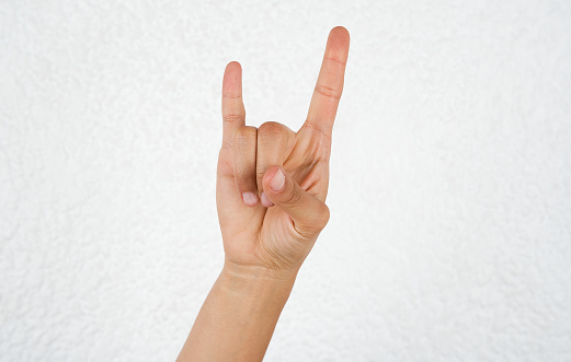 Rock hand gesture on white background