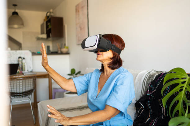 istock Middle aged latin lady in a light blue shirt discovering new technology with virtual reality headset in the apartment 1480424905