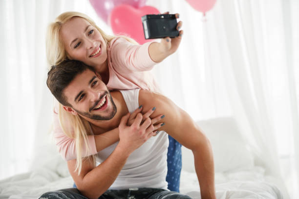 istock Cheerful young couple taking a selfie together with a digital camera 1480425752