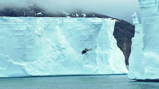 Antarctic research helicopter flies towards distance icefield stock video