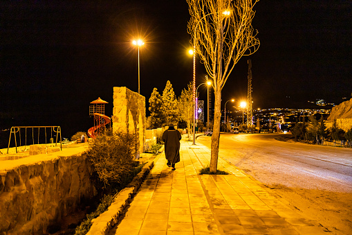 Wadi Musa,  Jordan March 23, 2023 A person walking alone at night on a road outside the city.