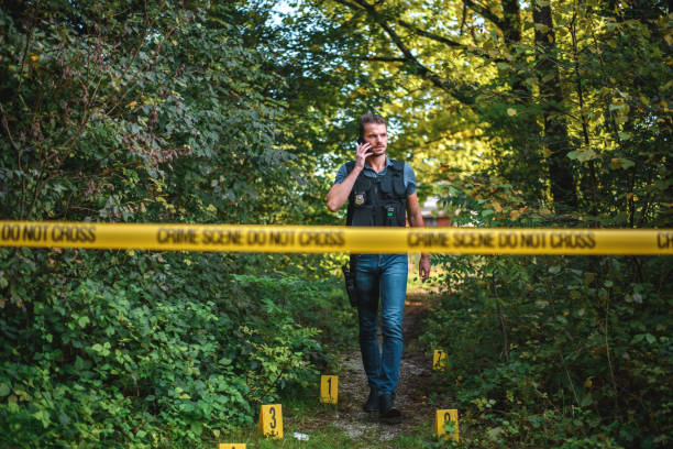 istock Focused Investigator Making a Phone Call While Approaching a Crime Scene 1480427688