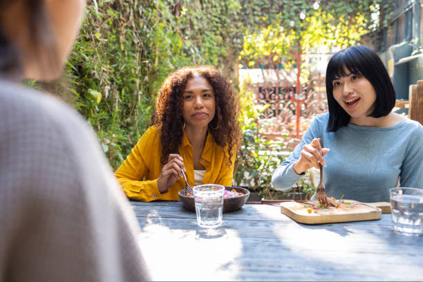 Female friends relaxing and talking, spending their afternoon together sitting in an outdoor cafe in Amsterdam. Female friendship concepts in Europe, on a lovely, sunny day.