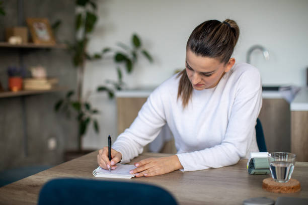 istock Woman taking notes of her blood pressure 1480438476