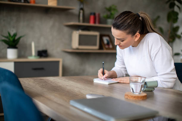 istock Woman taking notes of her blood pressure 1480438527
