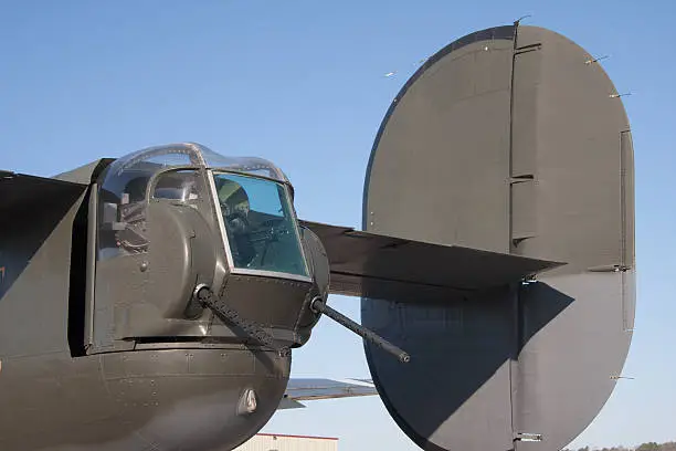 The tail gun mount of a B-25 WWII bomber with one of the twin tails visible.