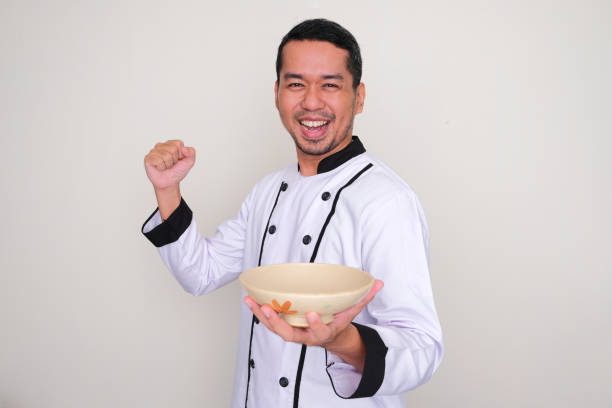 Closeup portrait of a male chef cook sharpening knife isolated on a white background
