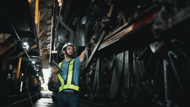 istock Engineer using tablet for working in the factory. Worker helping to repair and inspect the machine's readiness. Mechanical technicians are maintaining the engine in the train garage that is malfunctioning. 1480447026
