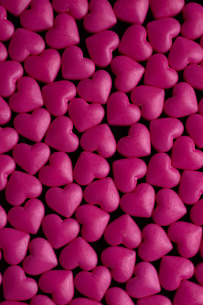 istock Pink heart sugar sprinkles on dark texture 1480450746