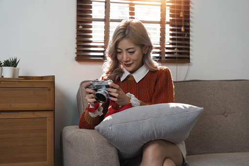 Portrait of pretty young woman looking at pictures from the camera.