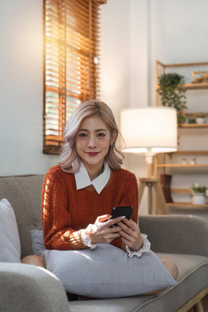 istock woman beautiful happy young woman resting on comfortable sofa, using cellphone application, web surfing useful information, playing games, shopping online 1480463671