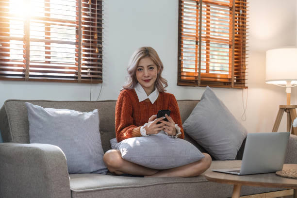 istock woman beautiful happy young woman resting on comfortable sofa, using cellphone application, web surfing useful information, playing games, shopping online 1480463723