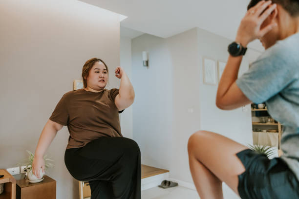 Learning homework out with coach, You doing great so keep going. Asian overweight lady enjoy weekend activity at home with her transgender coach, doing exercise at home. asian exercise diabetes stock pictures, royalty-free photos & images