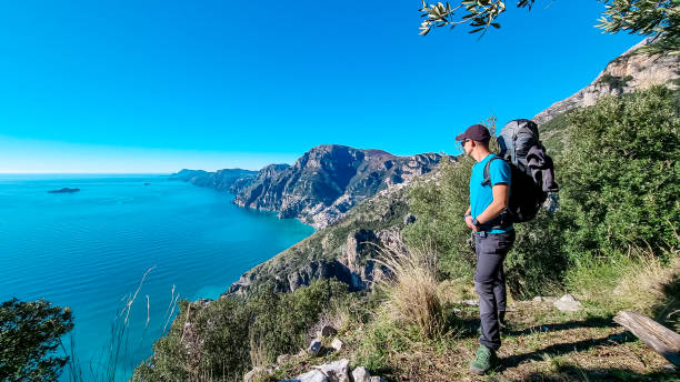 istock Praiano - Man with backpack enjoying scenic view from hiking trail between Positano and Praiano at the Amalfi Coast, Campania, Italy, Europe 1480477940
