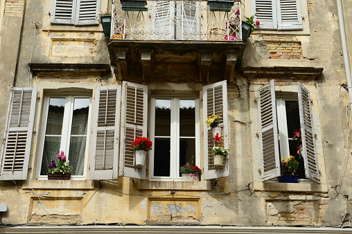 Bougainvilia and jasmine flower vines framing an old stone house window in the medieval town of Saint Paul de Vence, French Riviera, South of France