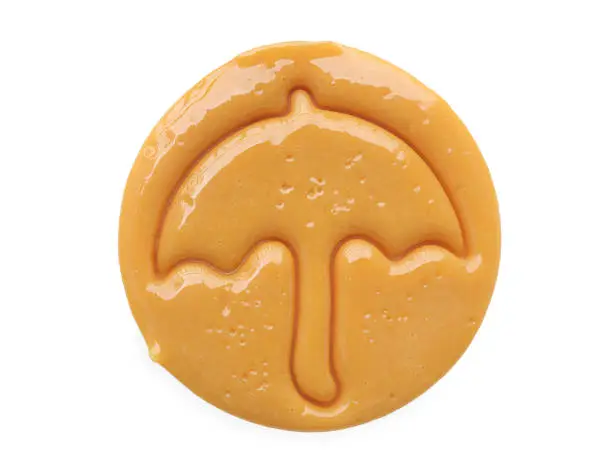 Photo of Dalgona candy or Ppopgi. Sugar Honeycomb cookie with umbrella shape on white background with clipping path. candy challenge