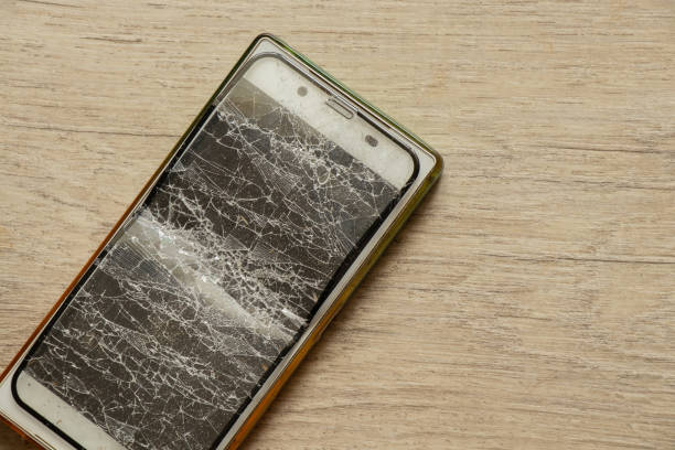 istock touch mobile phone and broken tempered glass on an isolated background, glass replacement 1480482150