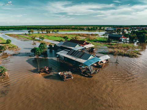 Stilz Houses in cambodian Village of Kampong Phluk Floating Village Aerial Drone Point of View. Stilt Houses, Fishing Boats and Fishing Farm Houses of Kampong Phluk - the well known Floating Village near Siem Reap and Lake Tonle Sap - situated close to the watered rural rice fields. Edited, Modified Colors and strong photo processing. Kampong Phluk Floating Village, Siem Reap Province, Prasat Bakong, Cambodia, South East Asia, Asia.