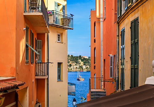 Traditional old terracotta houses on a street in Villefranche sur Mer Old Town on the French Riviera, South of France, overlooking Mediterranean Sea