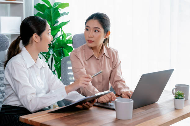 istock Two young businesswoman work together in office workspace. Enthusiastic 1480499585