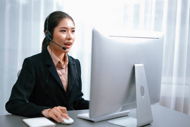 istock Enthusiastic asian call center with headset and microphone working on her laptop 1480502154