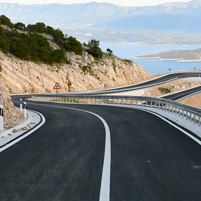 A winding and empty road on the seashore. Island of Brac, Croatia.New, recently built asphalt road.