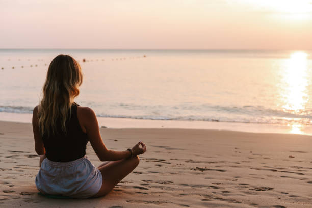 istock Young woman practicing yoga on the beach 1480509861