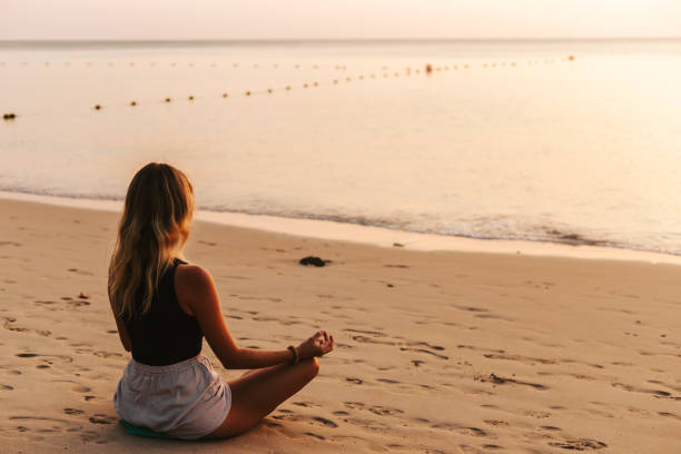 istock Young woman practicing yoga on the beach 1480511041