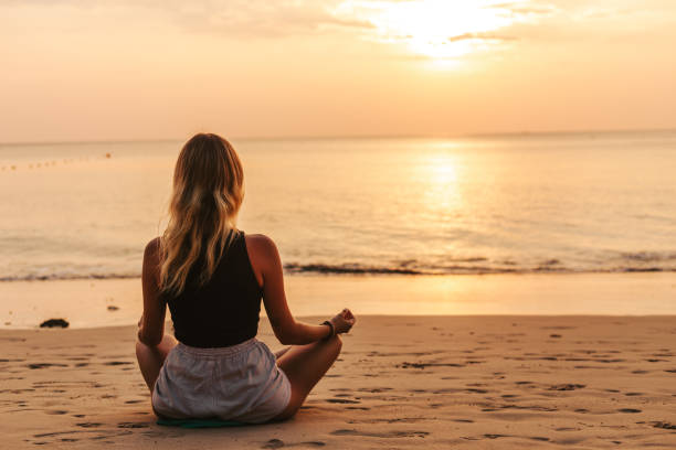 istock Young woman practicing yoga on the beach 1480511103