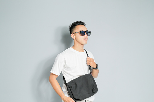 an Asian youth is wearing a black sling bag