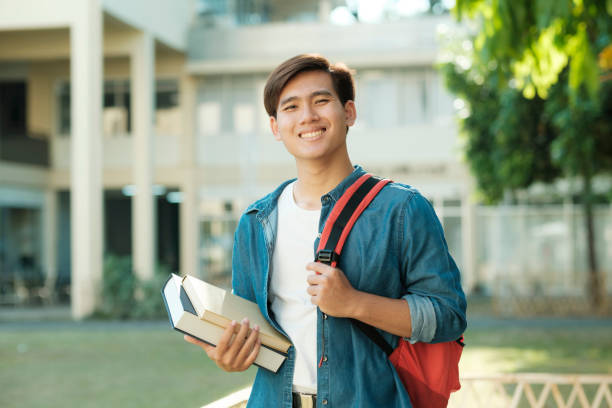 istock Student standing outdoor and holding books. 1480513899