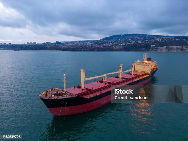 Aerial View Of A Bulk Carrier At Evening Showcases A Stunning Display Of Lights Reflecting Off The Water As The Massive Vessel Cuts Through The Waves Stock Photo - Download Image Now